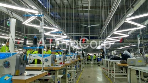 Smart garment factory production line with automated sewing machines and workers in industrial manufacturing environment