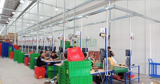 Factory assembly line with multiple workstations and material flow in organized production environment