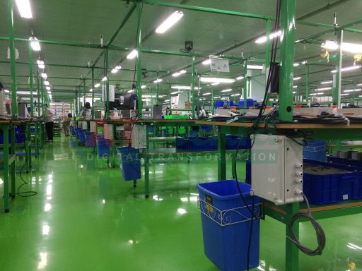 **SEO-optimized ALT text:** `Modern garment factory floor with organized production lines, workers, and real-time monitoring system in textile manufacturing facility`