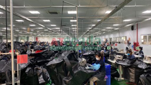 **SEO-optimized ALT text:** `Garment factory production line with workers operating sewing machines and real-time manufacturing process in textile industry`